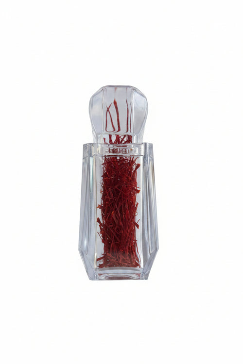 Clear glass bottle with red contents on a white background